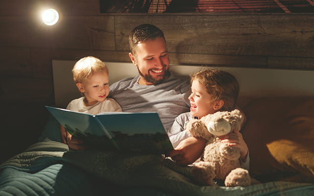 Vater liest Kindern etwas vor Vater liest Kindern etwas vor